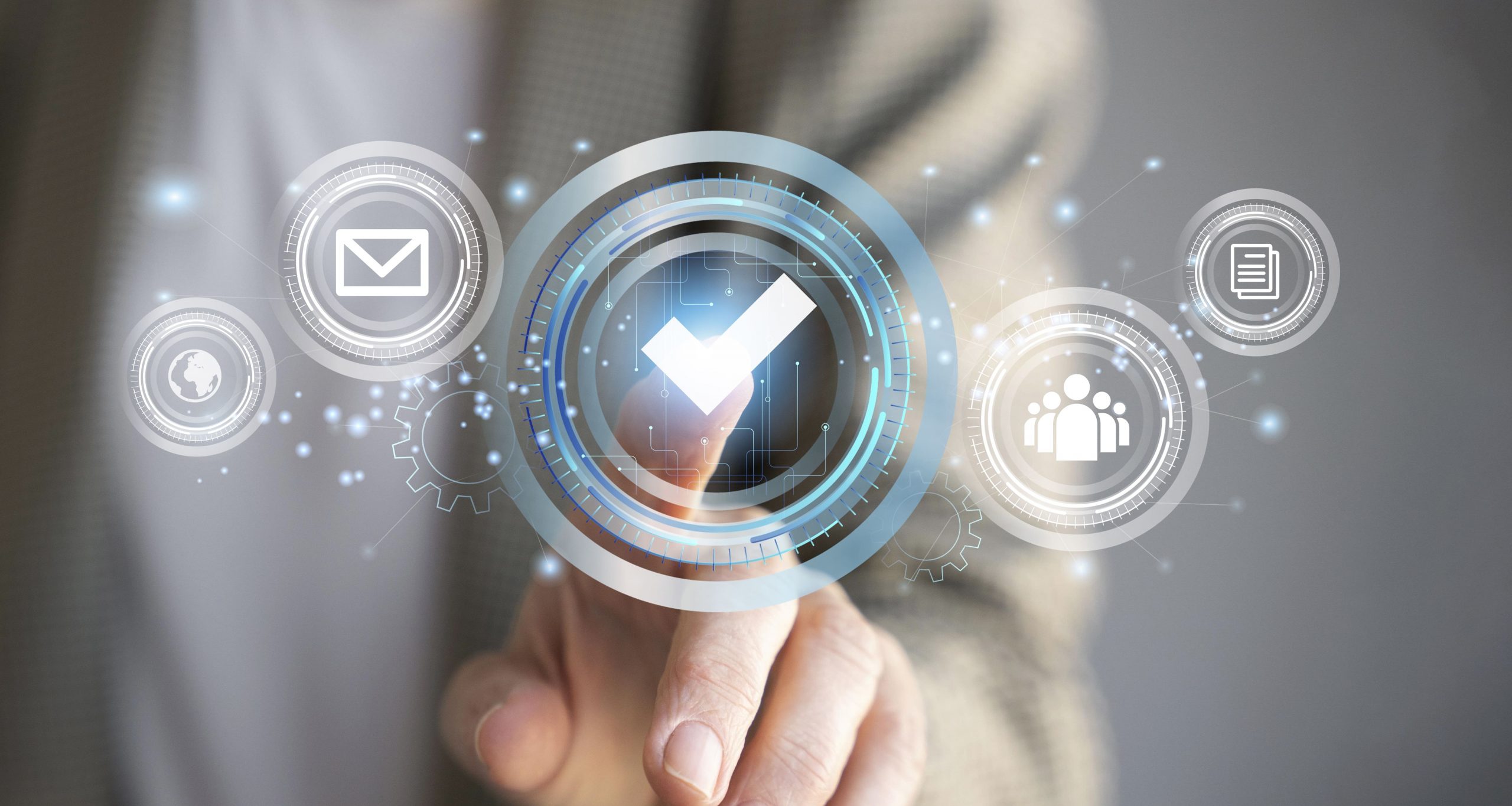Mão de uma pessoa tocando um ícone digital com formato de “V”, que está ao lado de outros quatro ícones que representam mundo, e-mail, pessoas conectadas, assinatura digital A1 e arquivos.
